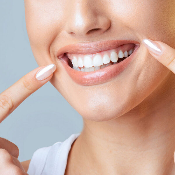 woman pointing at very straight white teeth