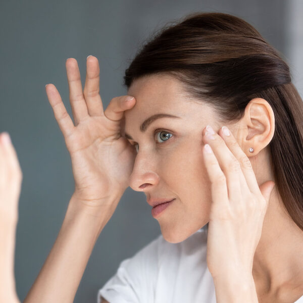 Woman looking in the mirror at lines on face